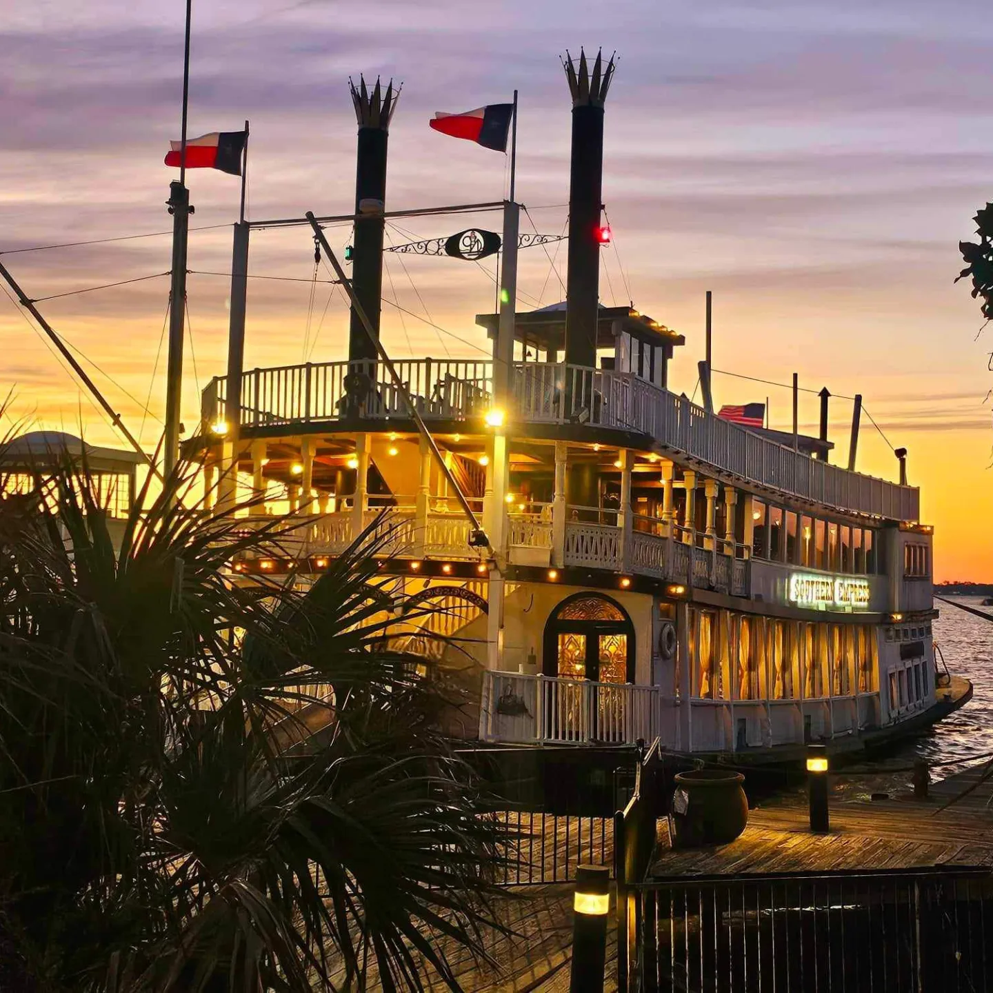 a sunset over a body of water with a city in the background